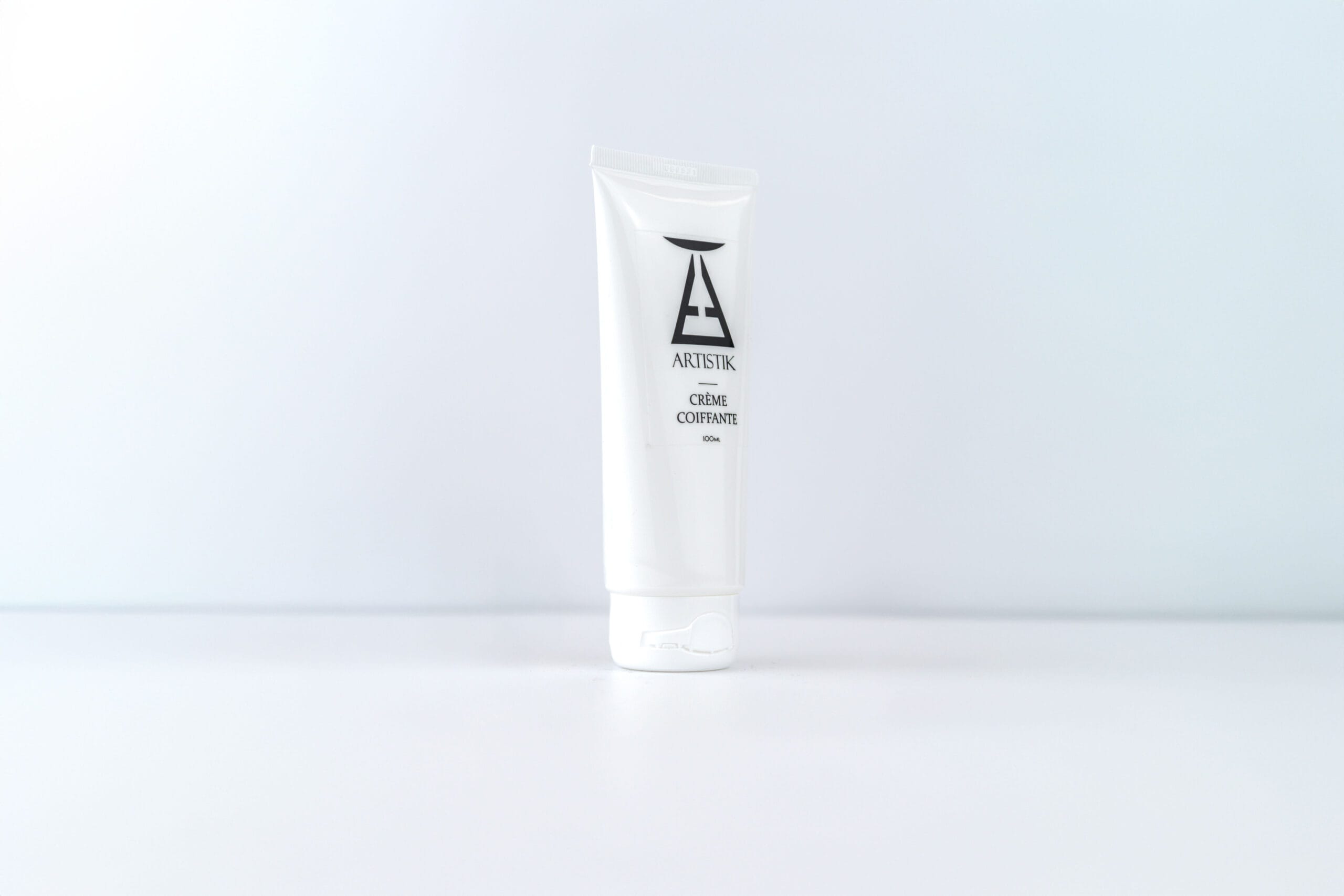 Crème coiffante ARTISTIK 100 g en gros plan, logo AT sur le tube