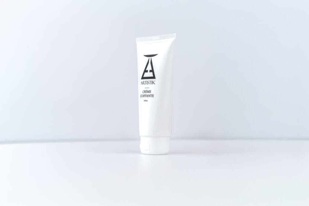 Crème coiffante ARTISTIK, tube légèrement pivoté sur fond blanc