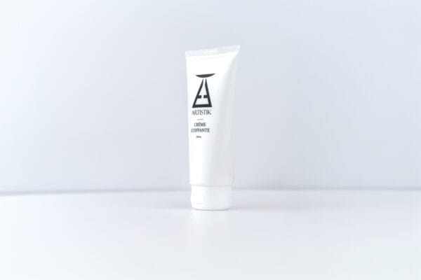 Crème coiffante ARTISTIK, tube légèrement pivoté sur fond blanc
