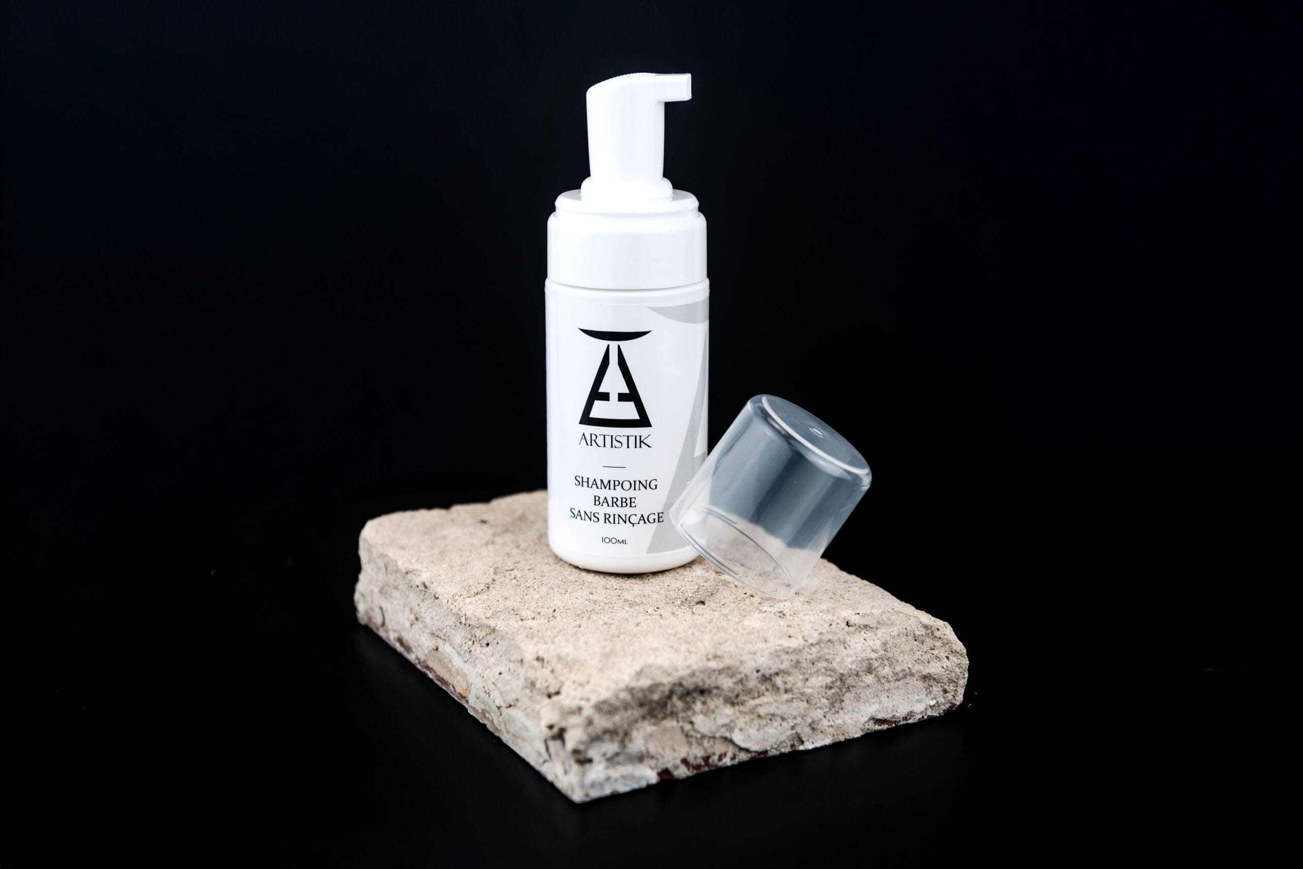 Shampoing barbe sans rinçage sur pierre fond noir avec bouchon